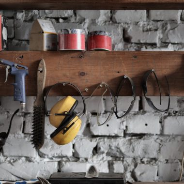 various instruments hanging on wooden board in garage