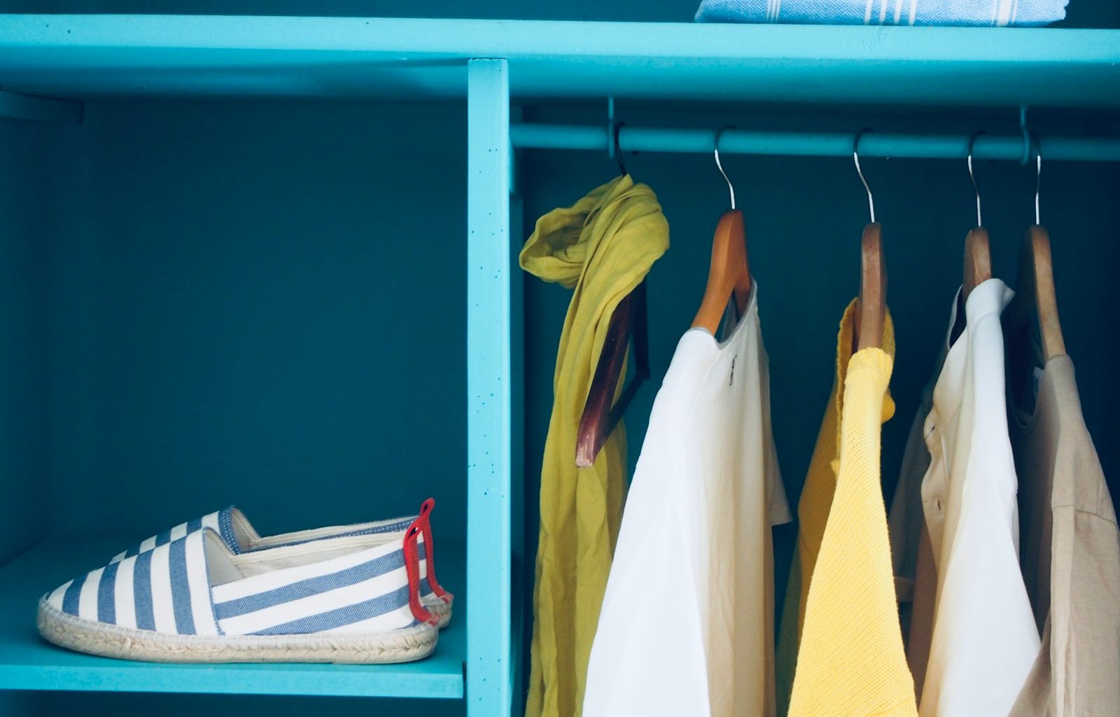 blue shelf with pair of slip-ons and five clothes