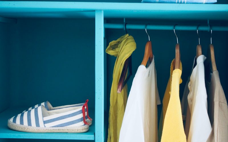 blue shelf with pair of slip-ons and five clothes