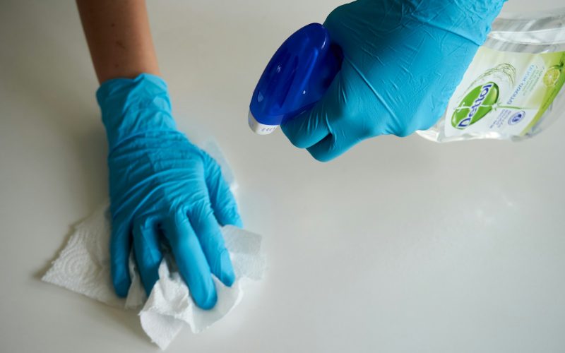 person in blue gloves holding white textile