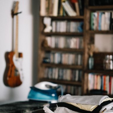 brown acoustic guitar on brown wooden shelf