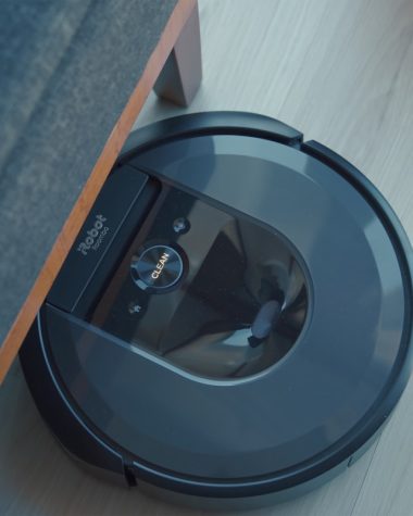 a robotic vacuum is on the floor next to a couch