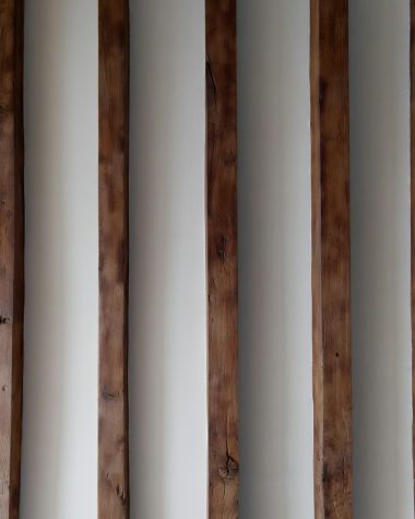 a row of wooden poles against a white wall