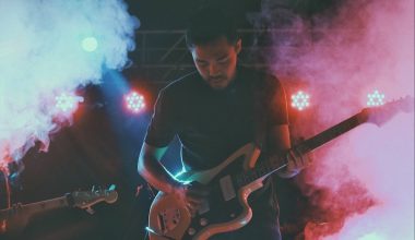 man in black crew neck t-shirt playing brown electric guitar