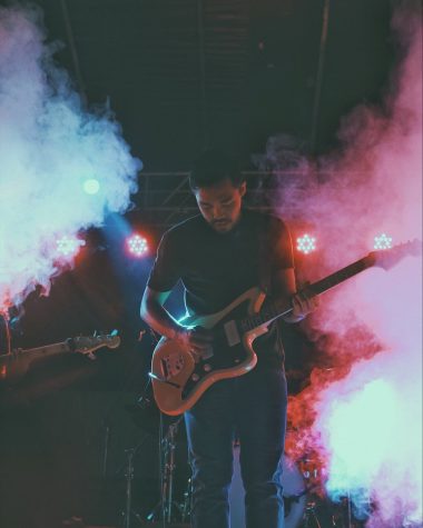 man in black crew neck t-shirt playing brown electric guitar