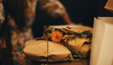 Warm-toned image of rustic wrapped gifts adorned with vibrant orange flowers, perfect for seasonal celebrations.