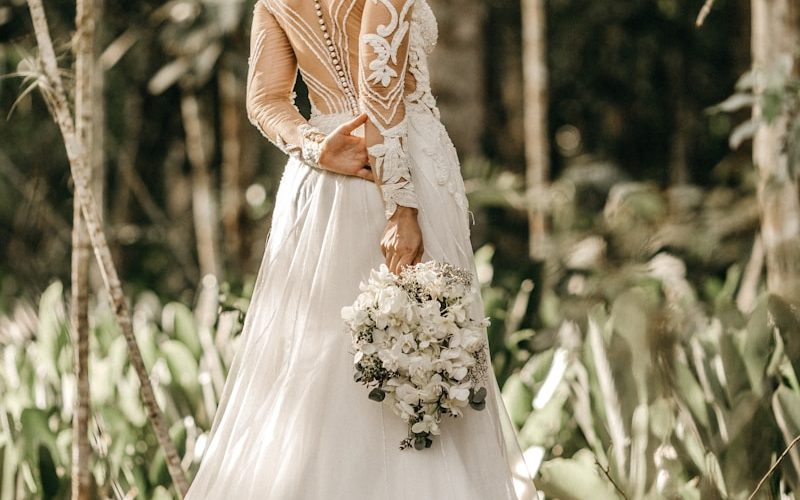 woman holding white flower bouquet during daytime