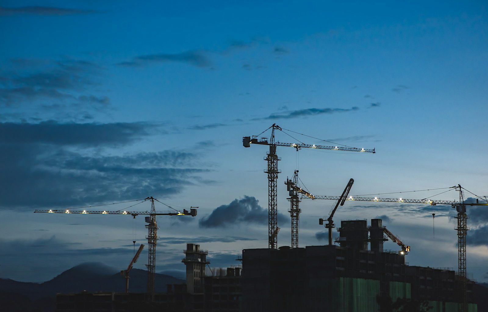 several cranes above the buildings