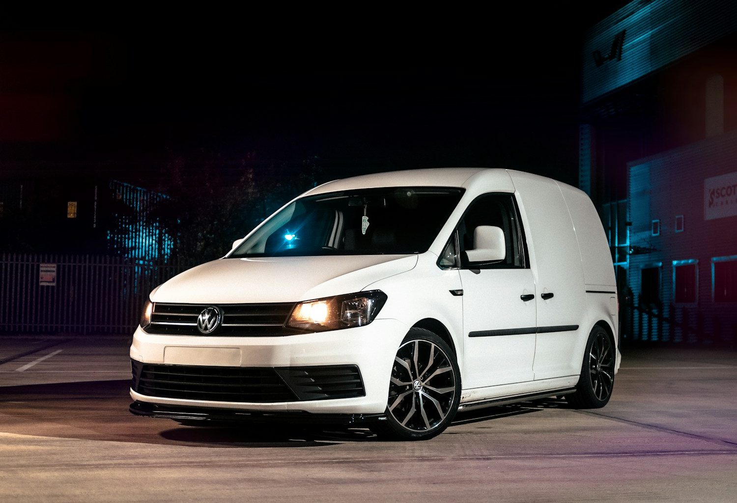 a white van parked in a parking lot at night