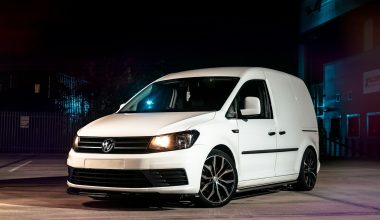a white van parked in a parking lot at night