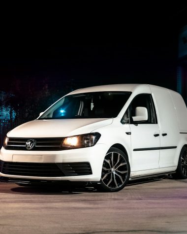 a white van parked in a parking lot at night