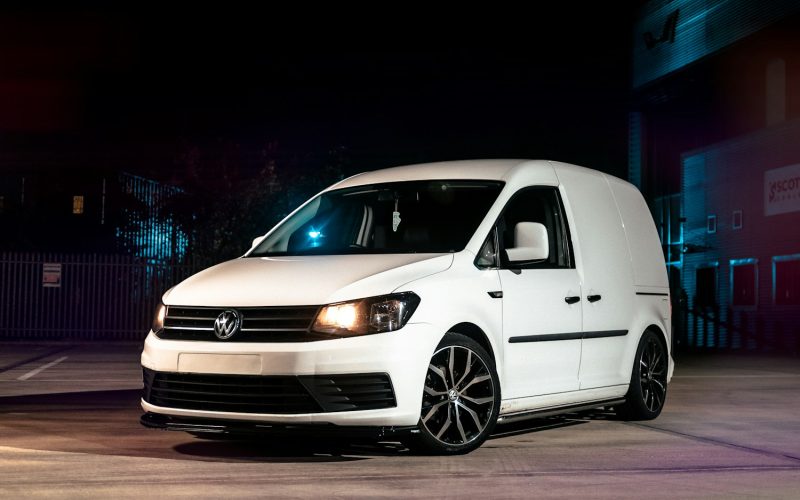 a white van parked in a parking lot at night