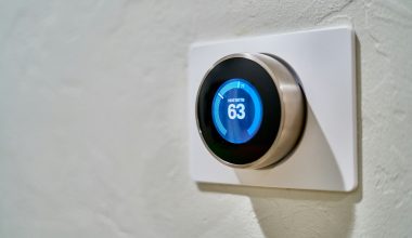 gray Nest thermostat displaying at 63