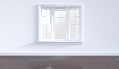 Lichte woonkamer met zonlicht dat via een open raam en spiegel diep de ruimte in valt