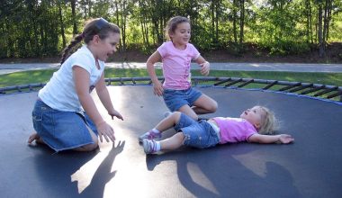 Kinderen springen op een trampoline in de tuin op een zonnige dag