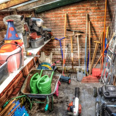 Tuingereedschap netjes hangend opgeborgen in een schuur