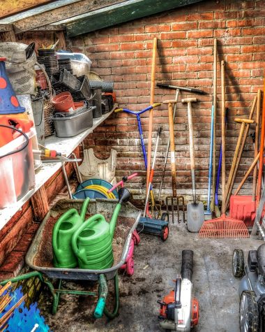 Tuingereedschap netjes hangend opgeborgen in een schuur