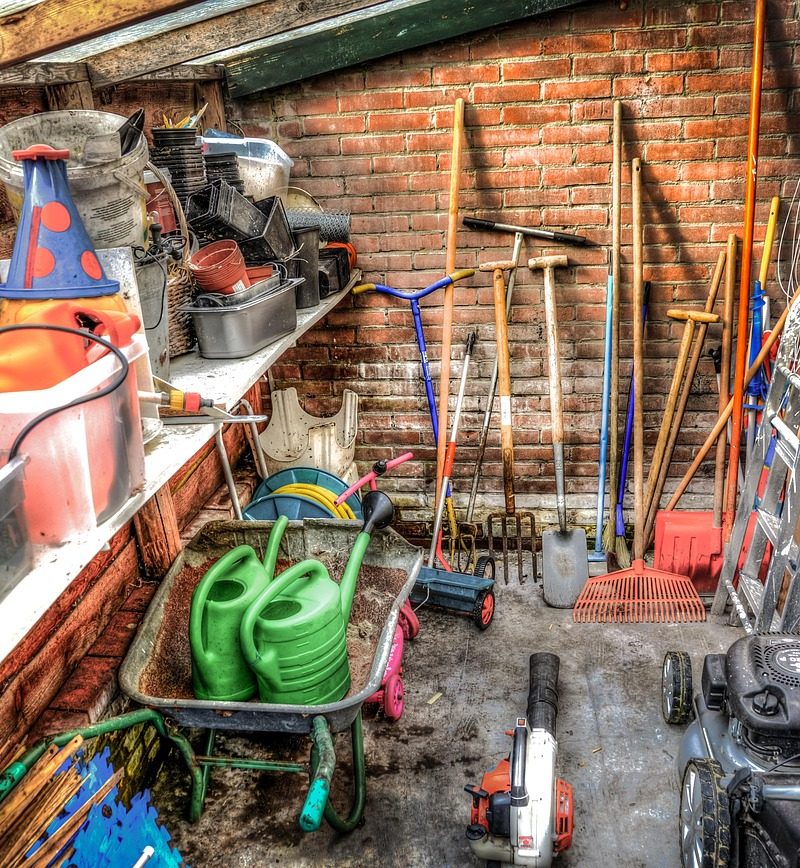 Tuingereedschap netjes hangend opgeborgen in een schuur