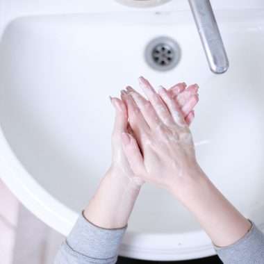 Persoon die de rubberen manchet van een tweedehands wasmachine controleert tijdens een bezichtiging
