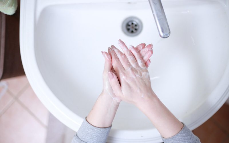 Persoon die de rubberen manchet van een tweedehands wasmachine controleert tijdens een bezichtiging