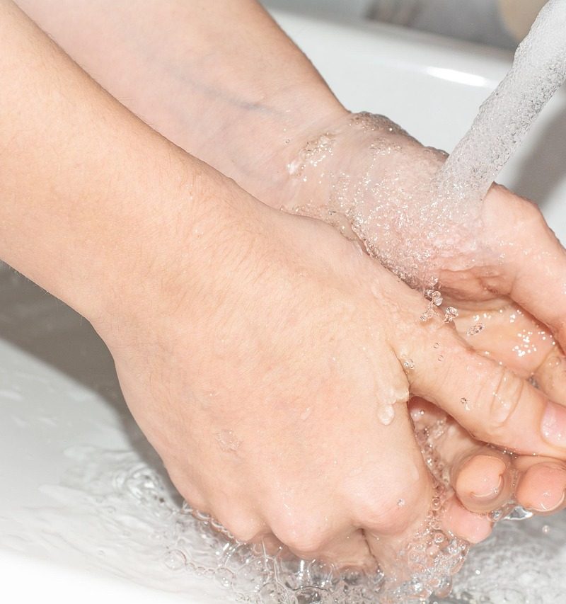 Schoonmaakmiddelen en doeken klaargelegd voor het schoonmaken van de badkamer