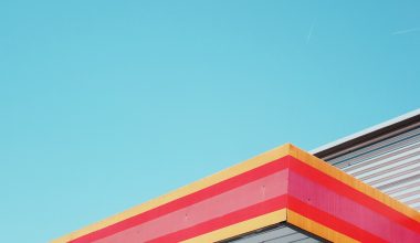 Iemand die dakgoten schoonmaakt met handschoenen en een ladder