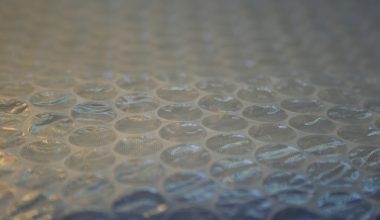 Persoon met beschermingsmasker en handschoenen die isolatiemateriaal verwijdert