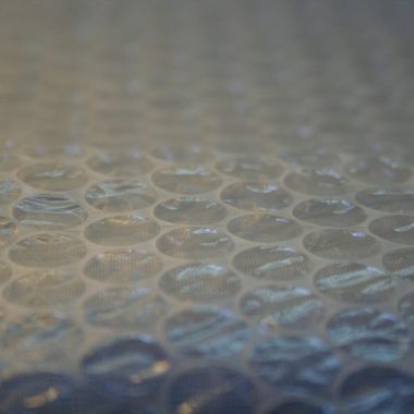 Persoon met beschermingsmasker en handschoenen die isolatiemateriaal verwijdert
