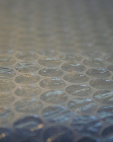 Persoon met beschermingsmasker en handschoenen die isolatiemateriaal verwijdert