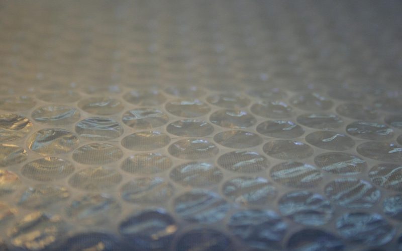 Persoon met beschermingsmasker en handschoenen die isolatiemateriaal verwijdert