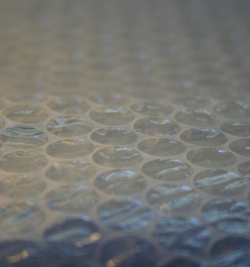 Persoon met beschermingsmasker en handschoenen die isolatiemateriaal verwijdert