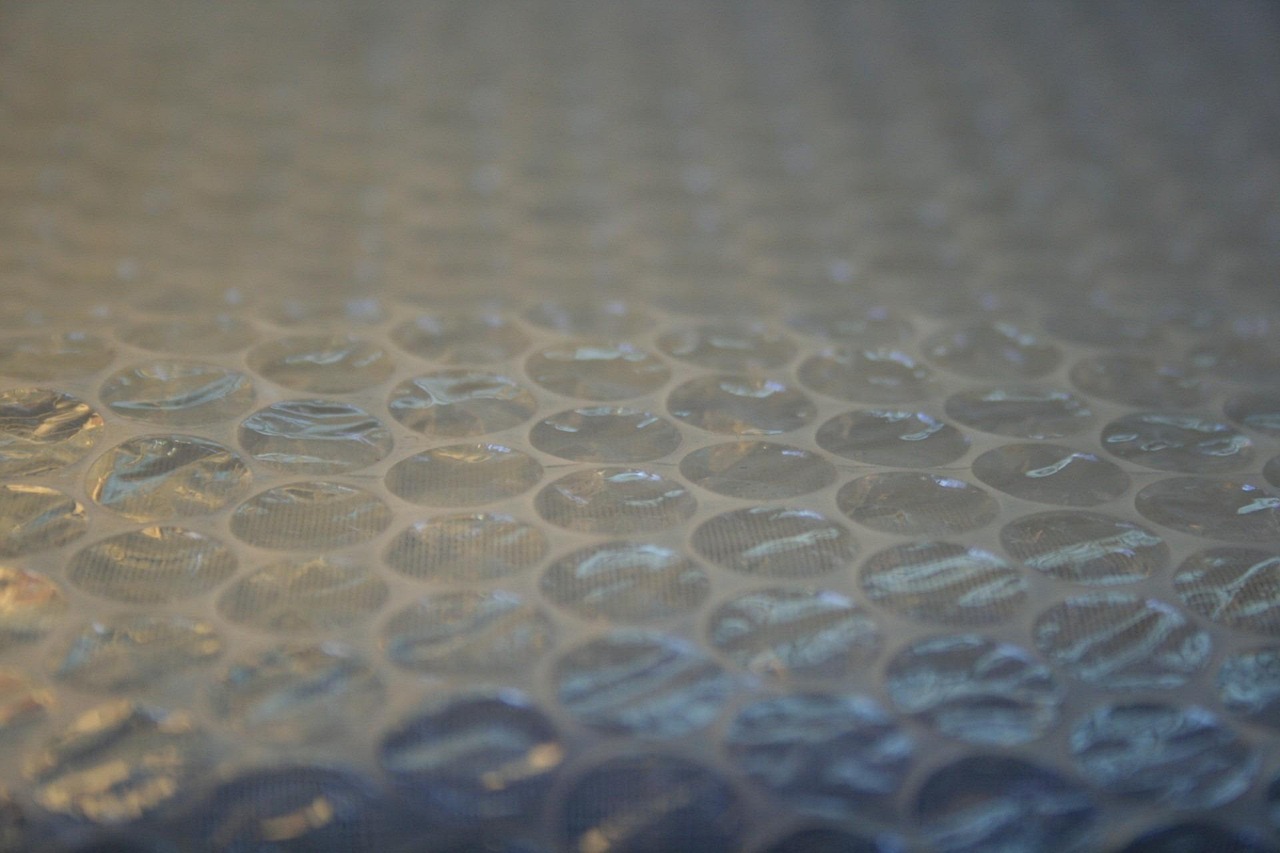 Persoon met beschermingsmasker en handschoenen die isolatiemateriaal verwijdert