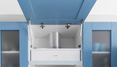 Close-up van een aluminiumfilter in een afzuigkap boven een fornuis