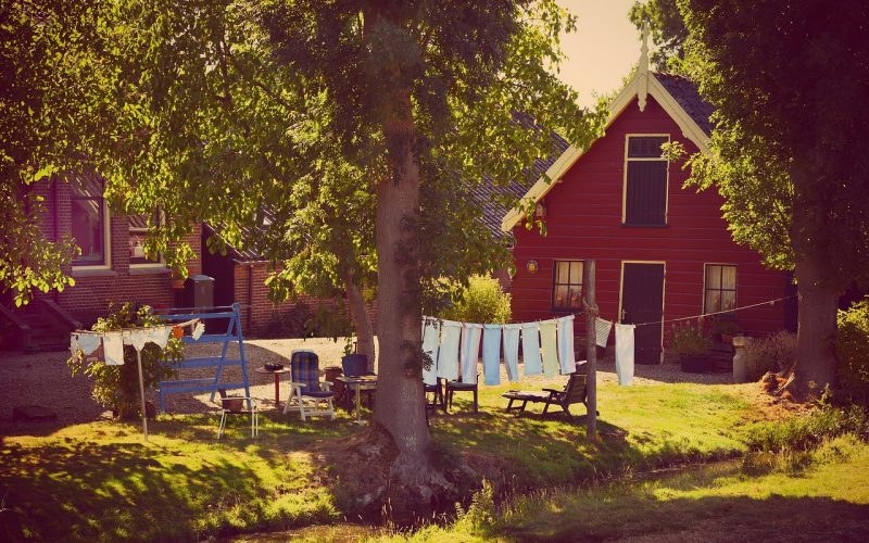 Ligbedkussens rechtop geplaatst in een tuin om te drogen aan het einde van het buitenseizoen