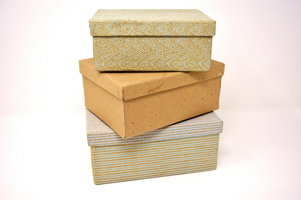 Een open doos met oude persoonlijke spullen zoals kleding en foto's op een houten vloer