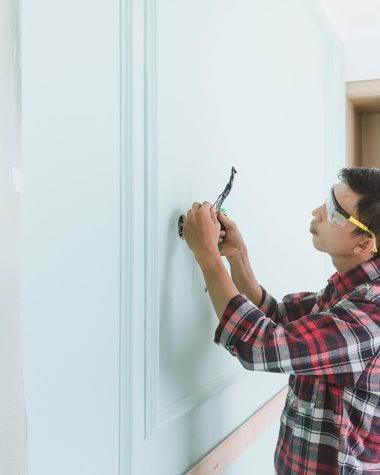 Persoon controleert een veiligheids checklist in een woning met rookmelder aan het plafond